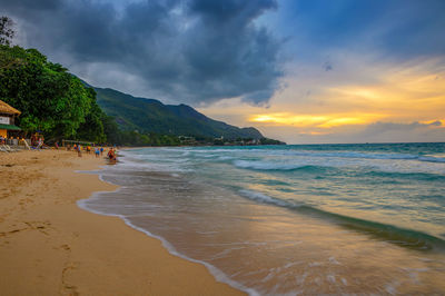 Scenic view of beach against sky during sunset