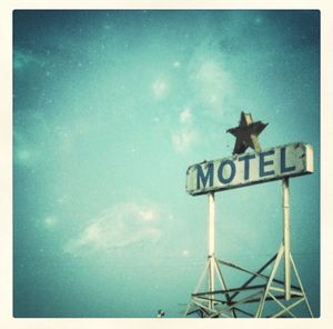 Low angle view of arrow sign against blue sky