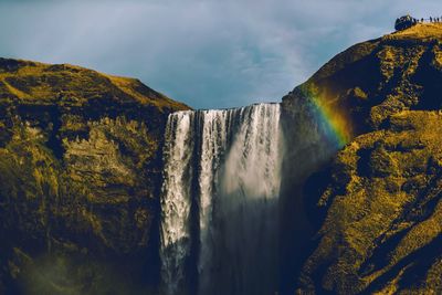 Scenic view of waterfall against sky