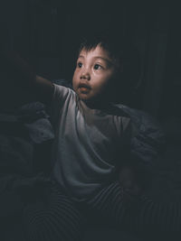 Portrait of cute girl lying on bed at home