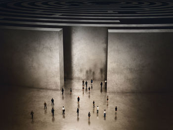 Digital composite image of people on table against wall