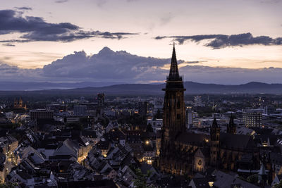 High angle view of city lit up at sunset