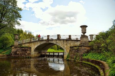 Arch bridge over river against sky