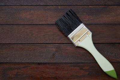 Directly above shot of paintbrush on wooden table