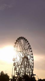 Low angle view of ferris wheel against sky during sunset
