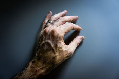 Close-up of human hand against wall