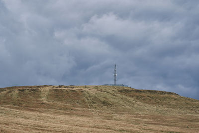 Low angle view of windmill on land against sky