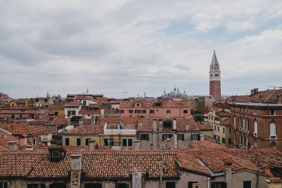 Houses in town against cloudy sky