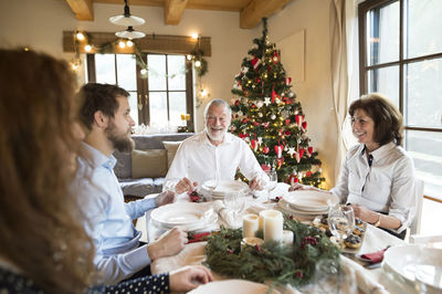 Smiling senior man with family at christmas dinner table