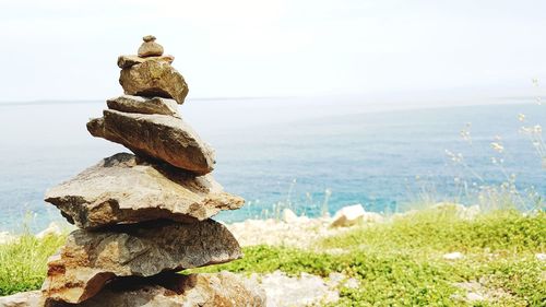 Stack of rocks in sea against sky