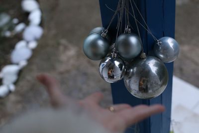 Close-up of hand holding silver christmas baubles