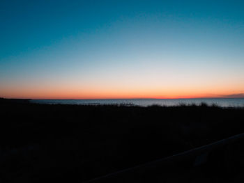 Scenic view of sea against clear sky during sunset