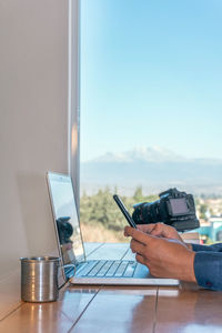 Midsection of woman using laptop at office