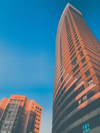 Low angle view of modern buildings against clear blue sky