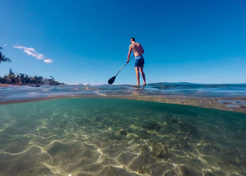 Full length of man on beach against blue sky