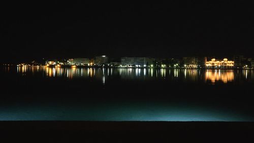 Scenic view of illuminated sea against sky at night