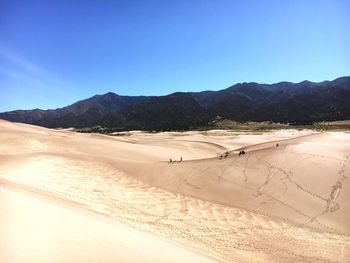 Scenic view of desert against clear blue sky