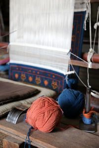 Yarn on workbench by loom weaving carpet at workshop