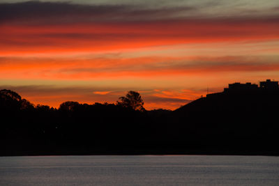 Scenic view of silhouette trees against romantic sky at sunset