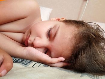 Close-up of baby sleeping on bed at home