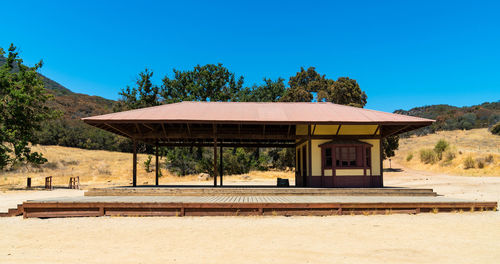 Built structure on landscape against clear blue sky
