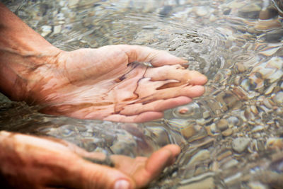 Cropped hand in river