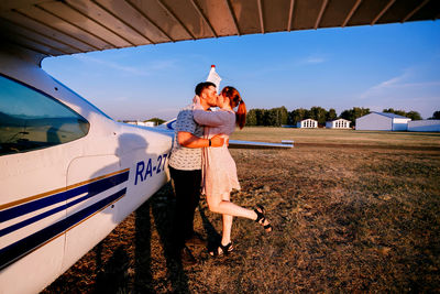 The image of people standing near the plane at the airport in the summer is beautiful and warm