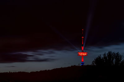 Low angle view of illuminated tower against sky at night