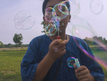 Midsection of man with bubbles in mid-air