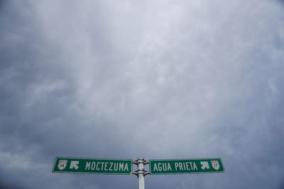 Low angle view of road sign against sky