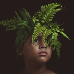 Close-up of young woman with green plant at night