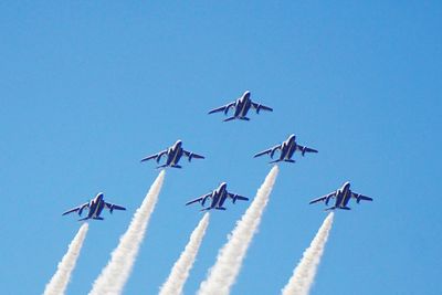 Low angle view of airplane flying against clear blue sky