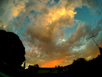 Low angle view of silhouette trees against cloudy sky