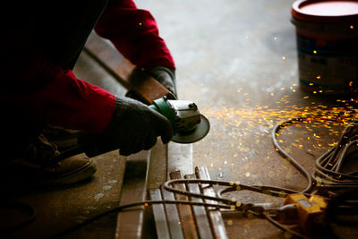 Welder used grinding stone on steel in factory with sparks, welding process at the industrial work