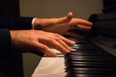 Cropped image of person playing piano