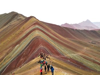 People in desert against clear sky