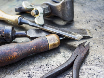 Close-up of various rusty tools on metal table