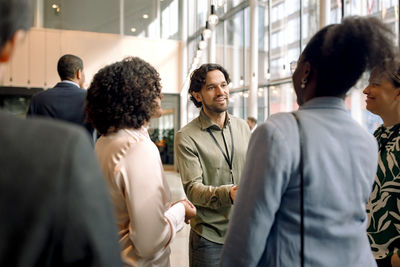 Businessman interacting with female entrepreneurs in networking event at convention center