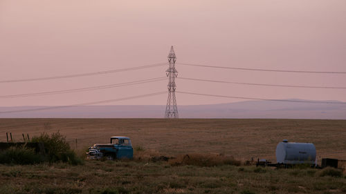 Electricity pylon on field against sky