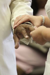 Midsection of couple holding hands