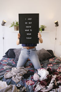 Midsection of woman holding text on paper at home