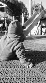 Rear view of boy sitting outdoors