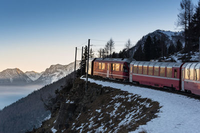 Train on snow covered mountains against sky