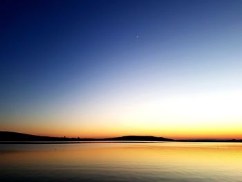 Scenic view of sea against clear sky at sunset