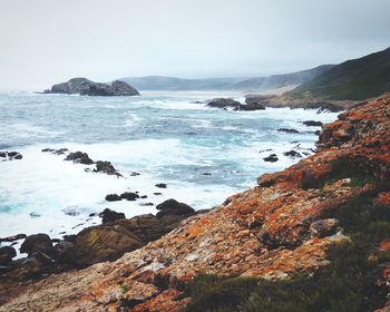 Scenic view of sea and mountains against sky