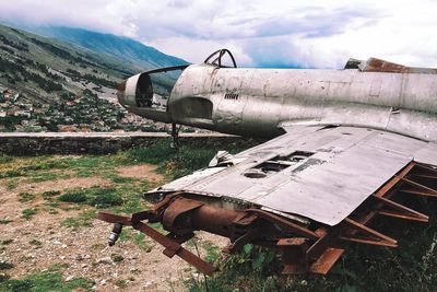 Damaged airplane on field against sky