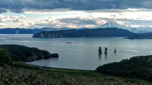 Scenic view of sea and mountains against sky