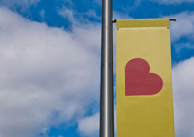 Low angle view of road sign against sky