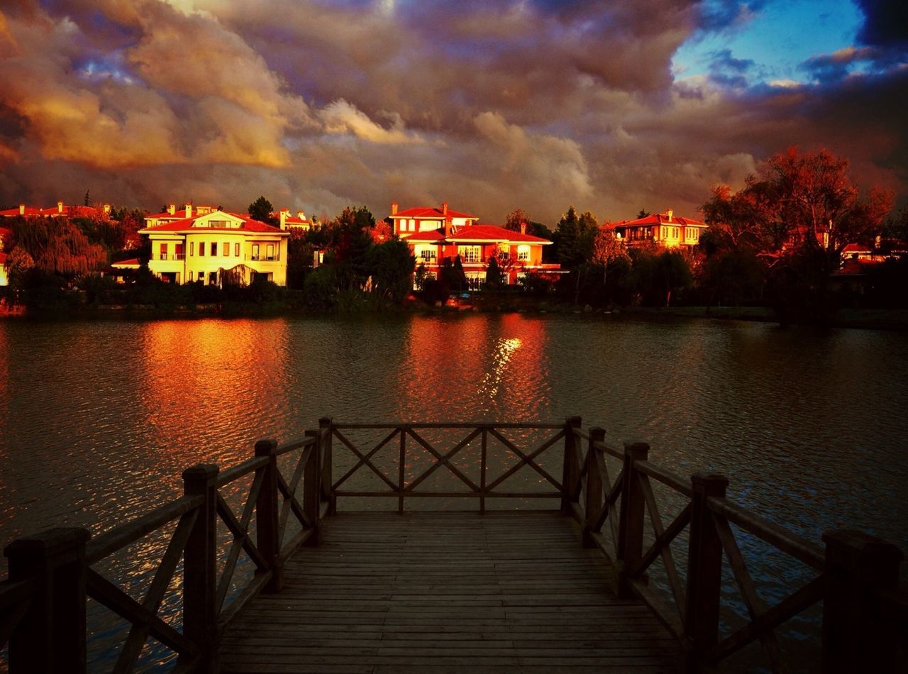 architecture, built structure, water, sky, building exterior, cloud - sky, sunset, river, reflection, railing, cloudy, cloud, lake, dusk, waterfront, pier, connection, house, illuminated, nature