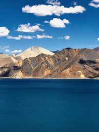 Scenic view of sea and mountains against sky